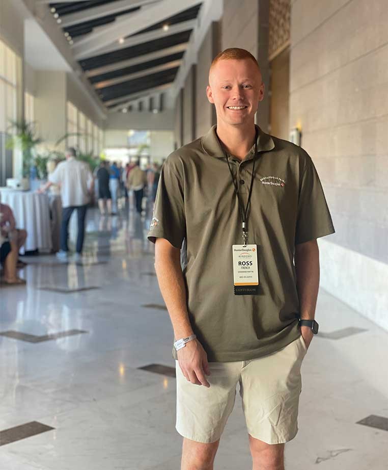 A man posing for a photo in a convention area